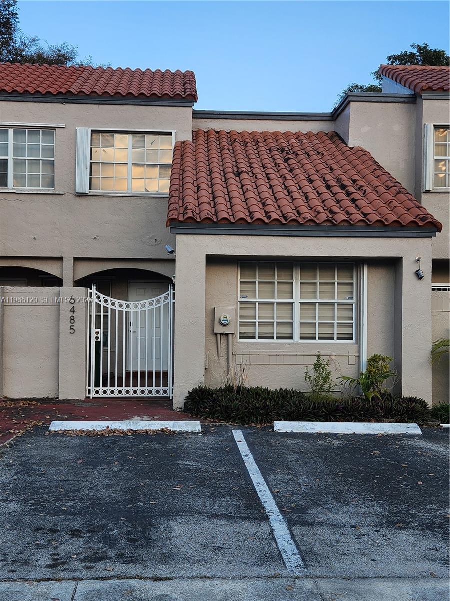 A two-story townhouse exterior features a red tile roof, beige stucco walls, and a gate — 6485 SW 129th Ave, Miami FL 33183, MIAMI, FL