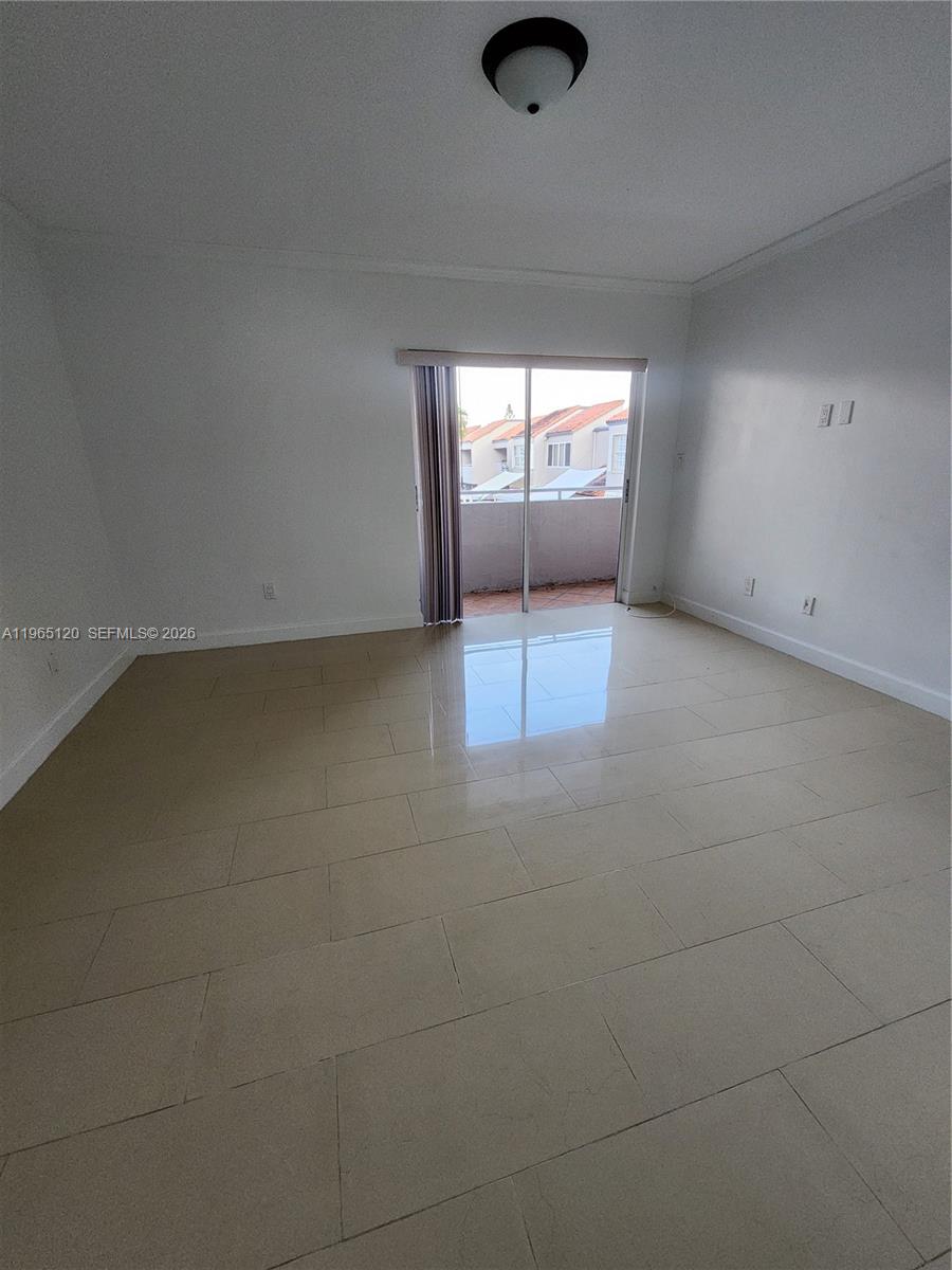 An empty room features light-colored tile flooring, white walls, and a sliding glass door — 6485 SW 129th Ave, Miami FL 33183, MIAMI, FL