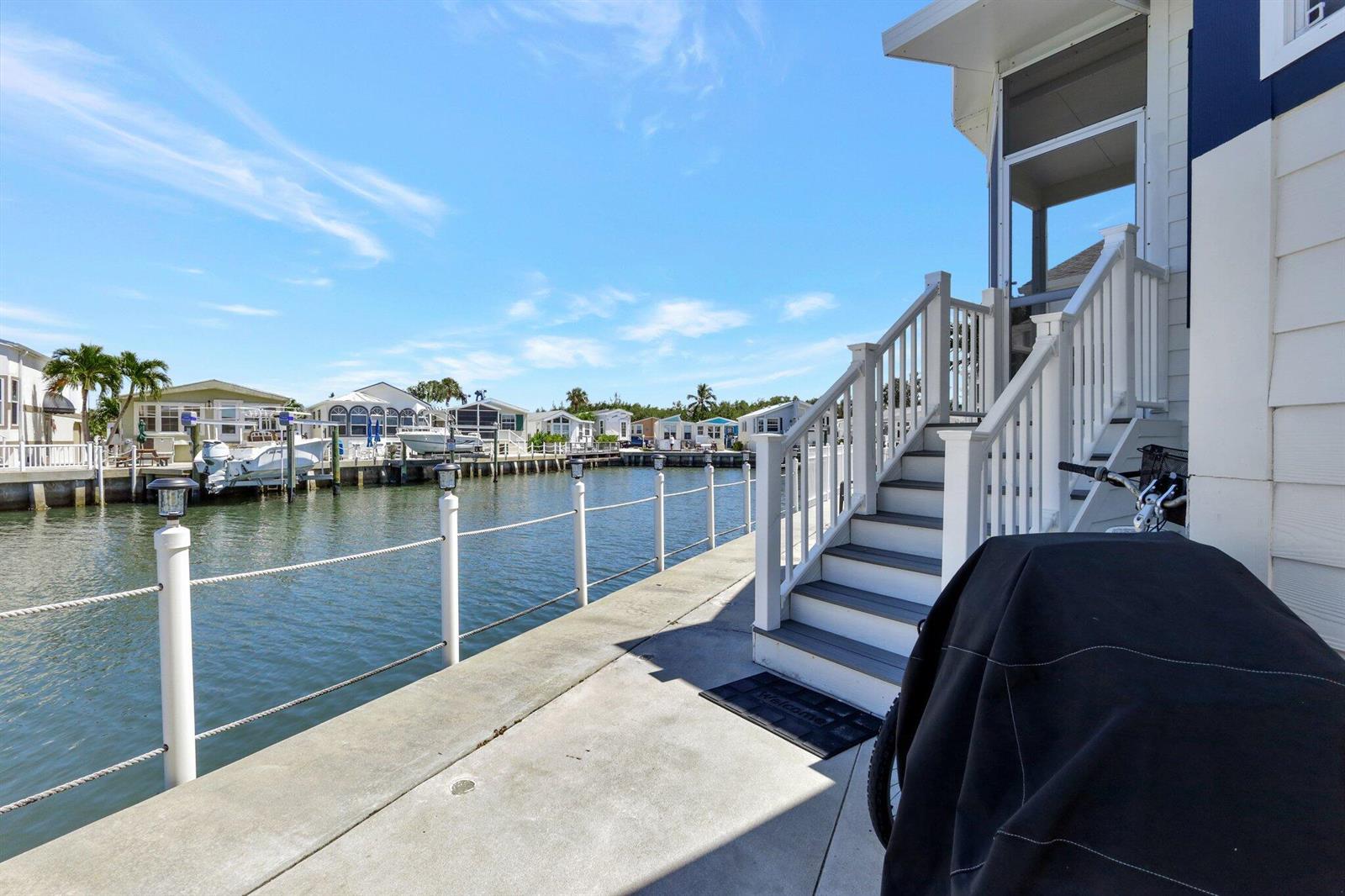 A concrete dock with white railings leads to stairs ascending to a waterfront home — 10701 S Ocean Drive # 651, Jensen Beach FL 34957, JENSEN BEACH, FL