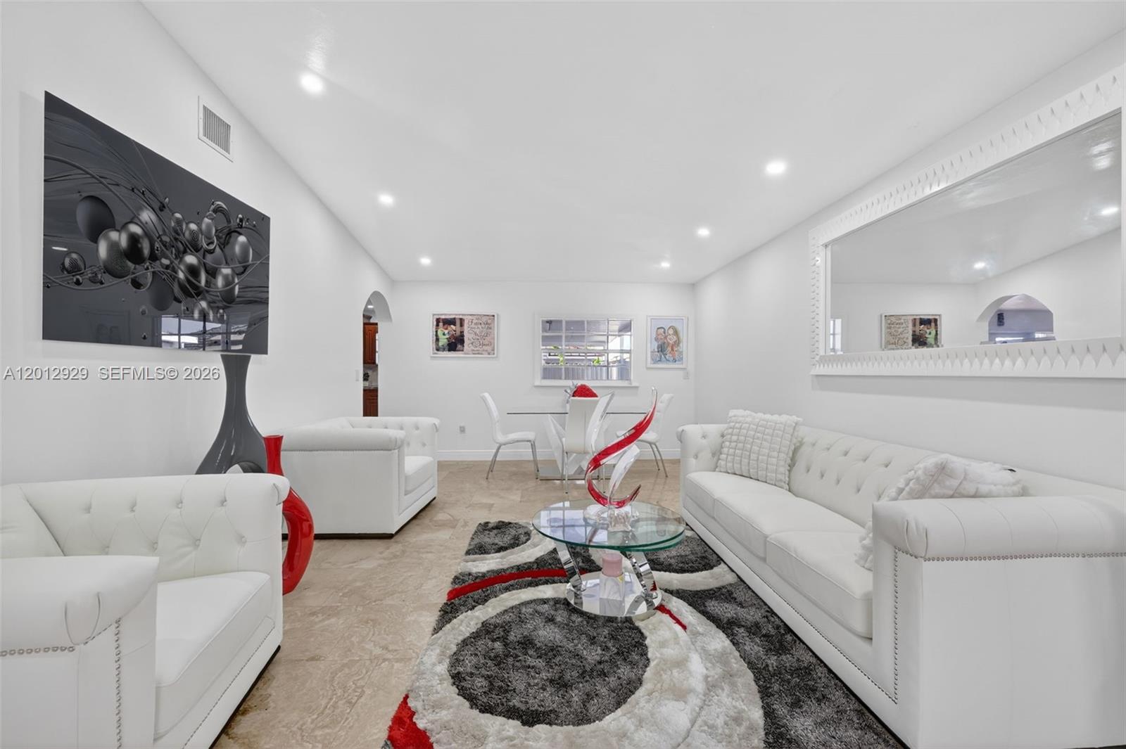 A bright living and dining area features white tufted furniture, tile floors, and a rug — 14661 SW 168th Ter, Miami FL 33177, MIAMI, FL