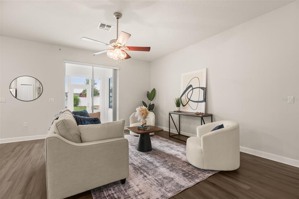 A living room features a beige sofa, two white armchairs, and a dark wood console table — 34004 ALAMEDA DRIVE, SORRENTO, FL