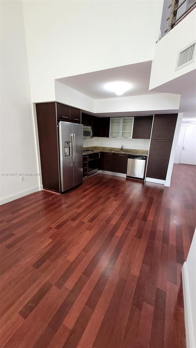 A kitchen features dark wood cabinets, stainless steel appliances, and hardwood flooring — 41 SE 5th St # 709, Miami FL 33131, MIAMI, FL