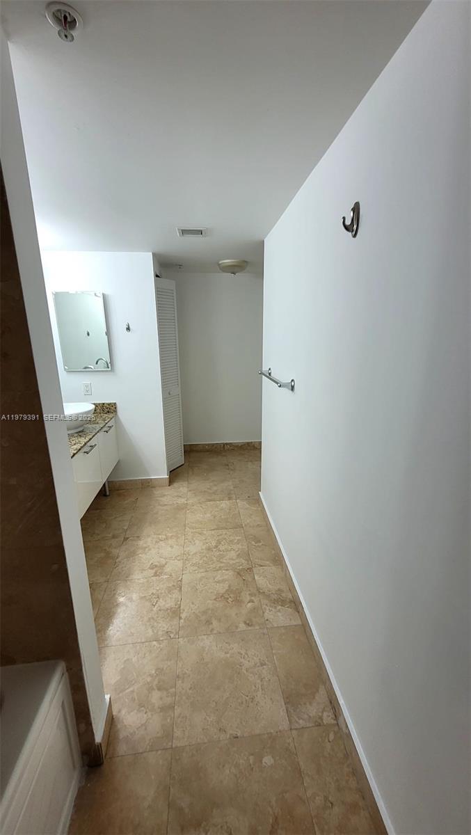 A bathroom features a vanity with a vessel sink, tiled flooring, and white walls — 41 SE 5th St # 709, Miami FL 33131, MIAMI, FL