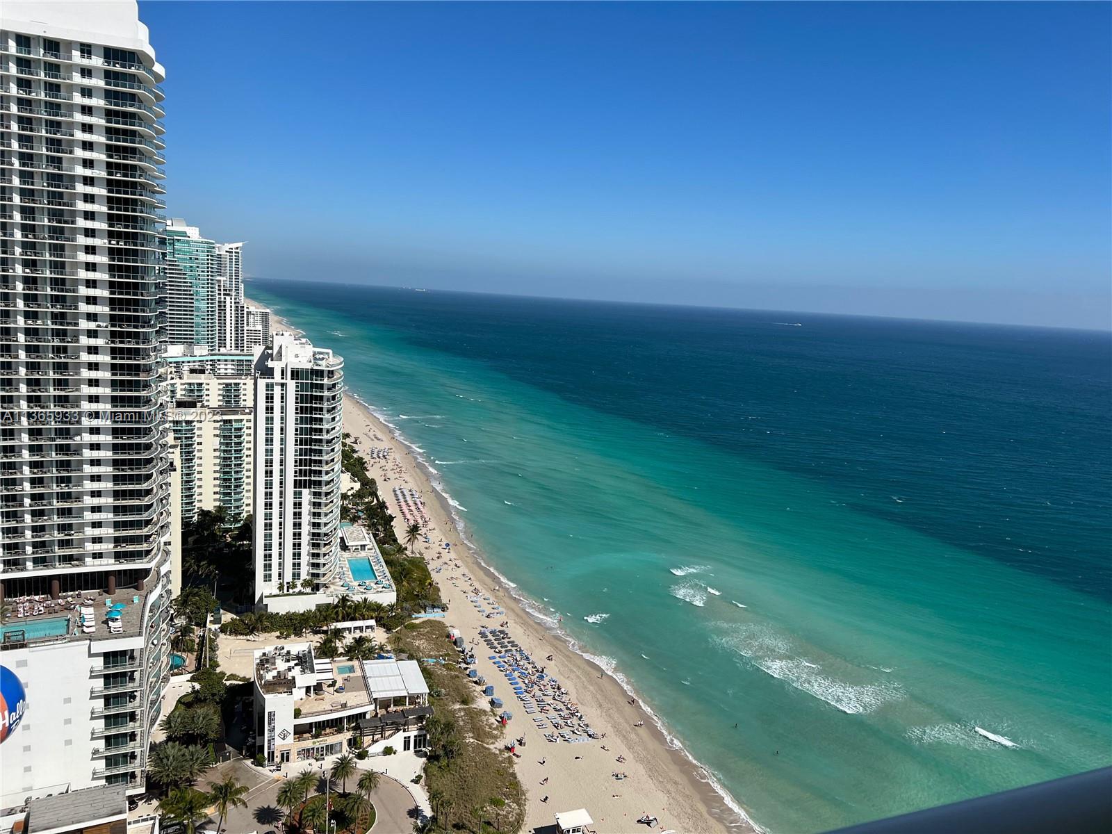 An aerial view shows high-rise residential buildings along a sandy beach and turquoise ocean — 1830 S Ocean Dr Available # 3511, Hallandale Beach FL 33009, HALLANDALE BEACH, FL