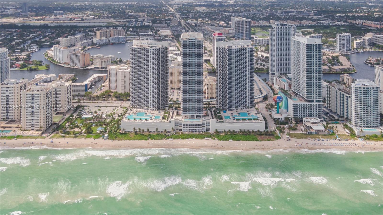 An aerial view shows several high-rise residential buildings situated directly along a sandy beach — 1830 S Ocean Dr Available # 3511, Hallandale Beach FL 33009, HALLANDALE BEACH, FL