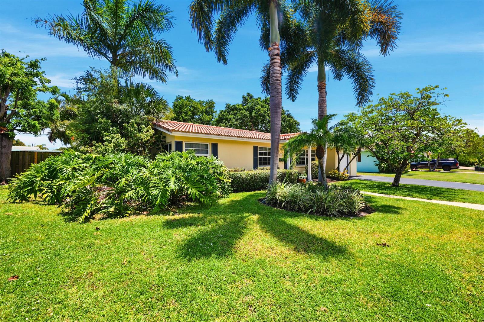 A yellow single-story house with a tile roof sits behind a lush green lawn — 1222 SW 5th Street, Boca Raton FL 33486, BOCA RATON, FL