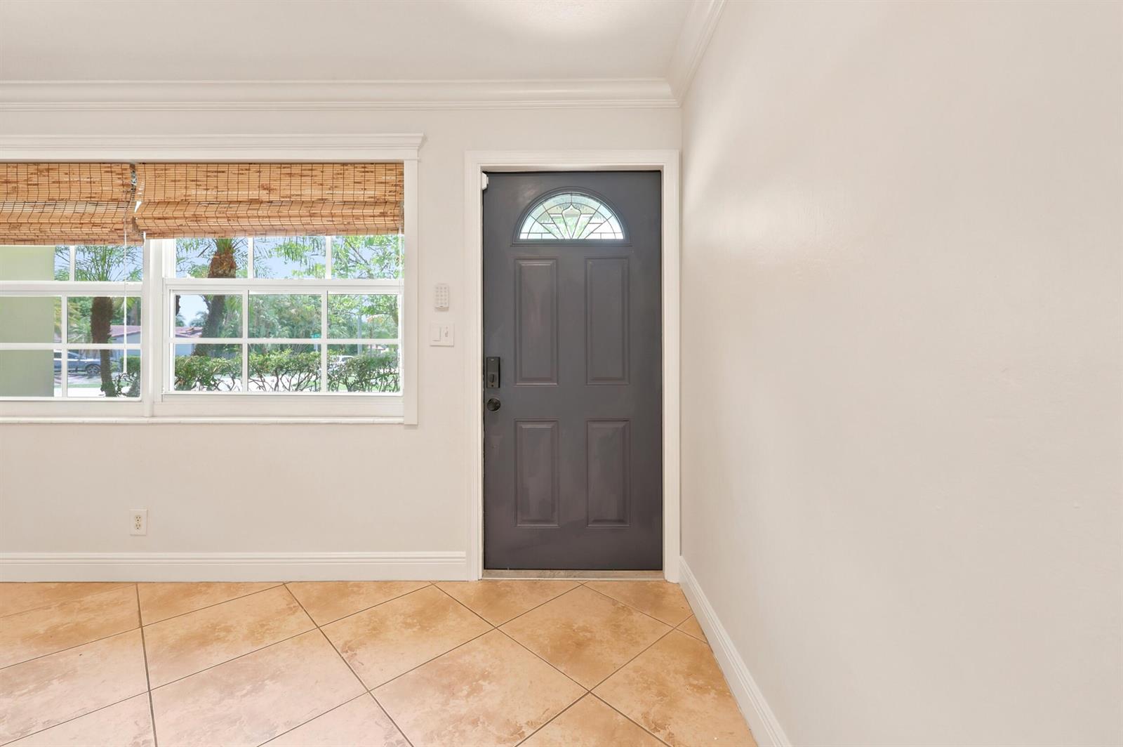 A room with beige tile flooring, a gray front door, and a window with blinds — 1222 SW 5th Street, Boca Raton FL 33486, BOCA RATON, FL