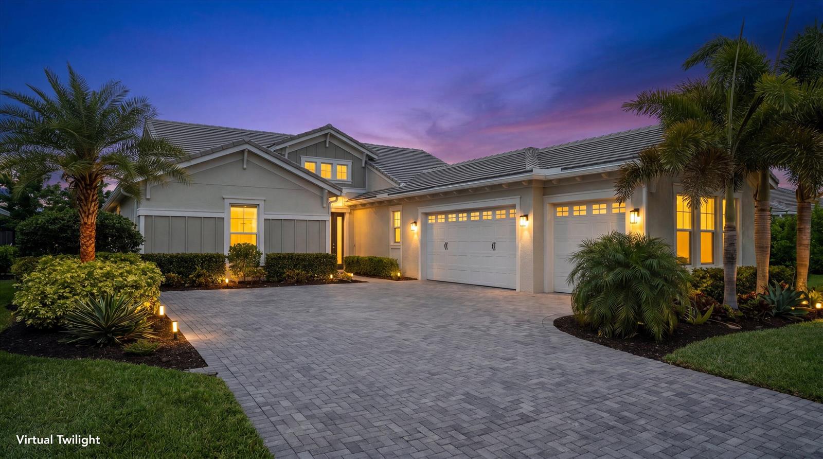 A single-story house with a paved driveway, three-car garage, and palm trees at twilight — 5919 Jasmine Lane, Westlake FL 33470, WESTLAKE, FL