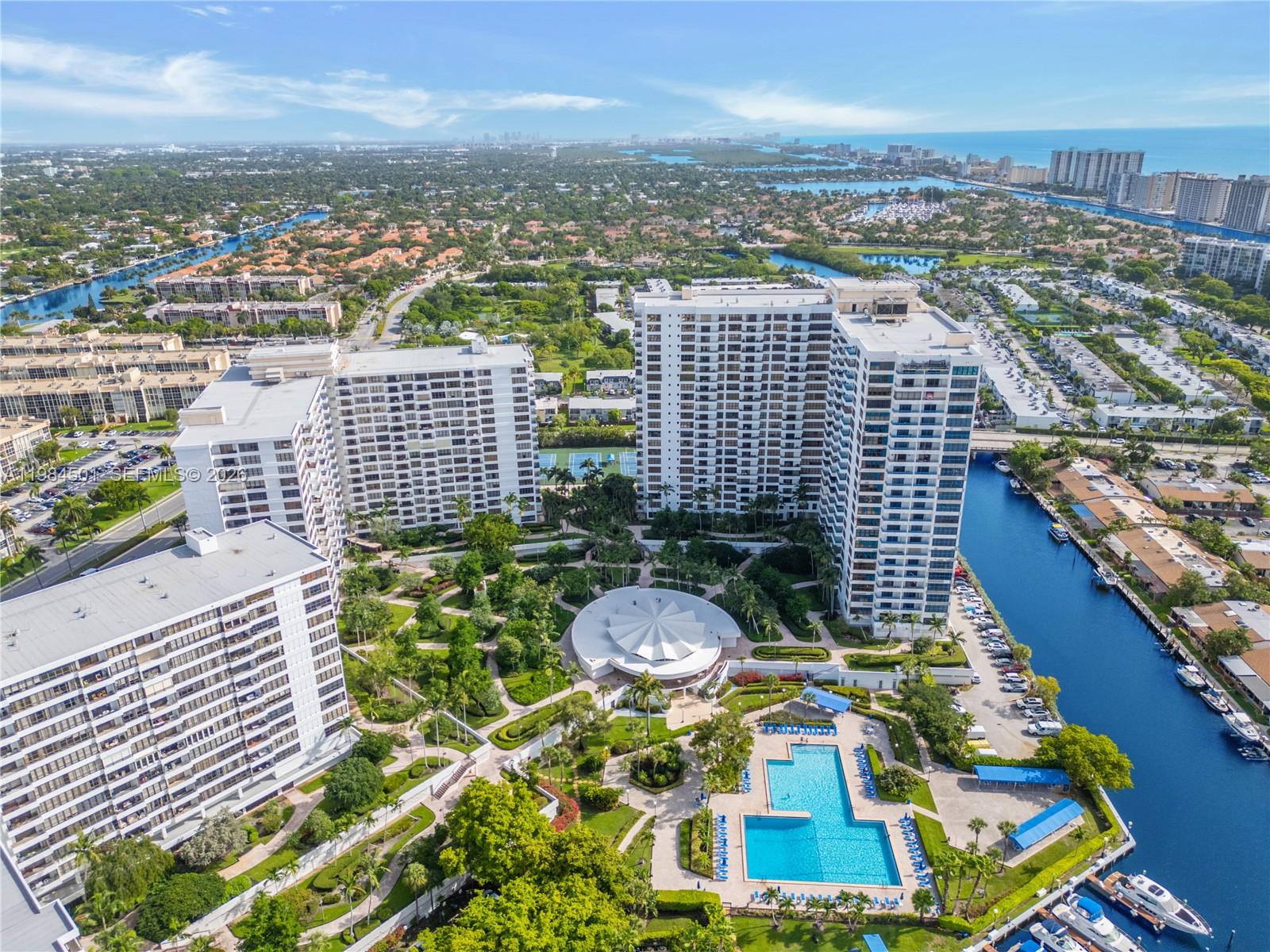 An aerial view shows multiple high-rise apartment buildings surrounding a central pool and garden area — 2500 Parkview Dr # 509, Hallandale Beach FL 33009, HALLANDALE BEACH, FL