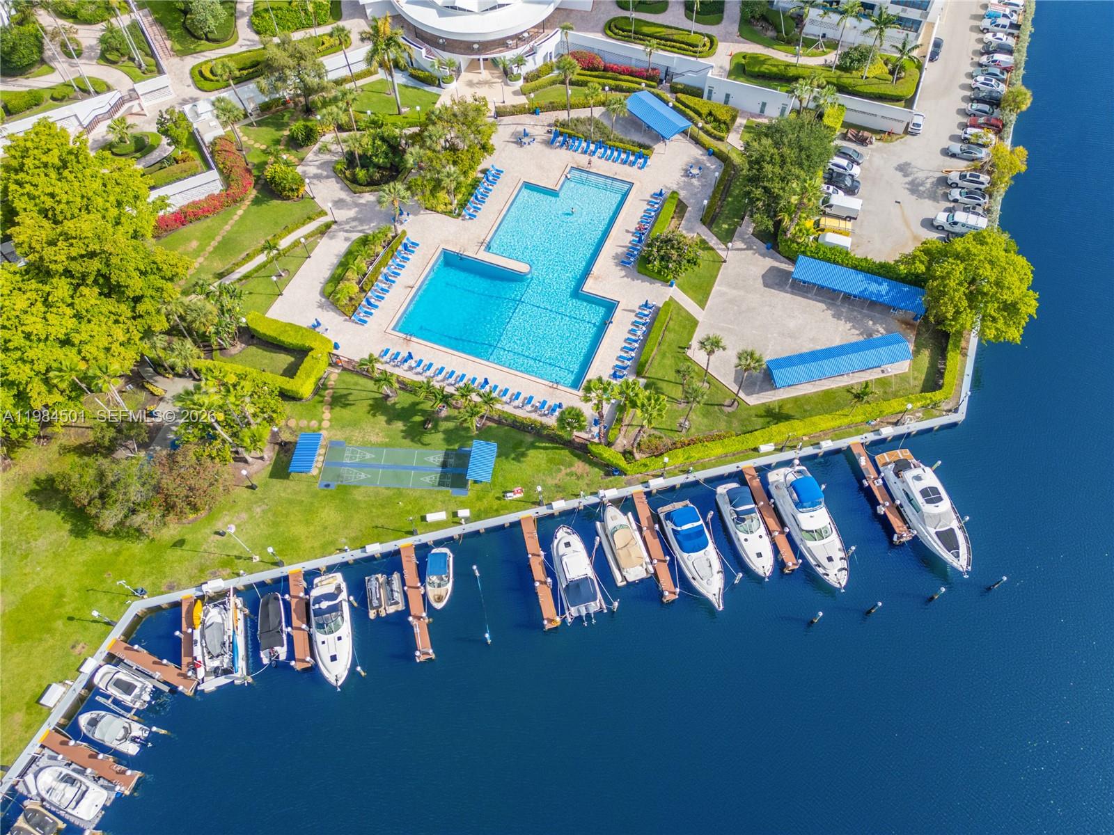 An aerial view shows a swimming pool, landscaped grounds, and a marina with docked boats — 2500 Parkview Dr # 509, Hallandale Beach FL 33009, HALLANDALE BEACH, FL