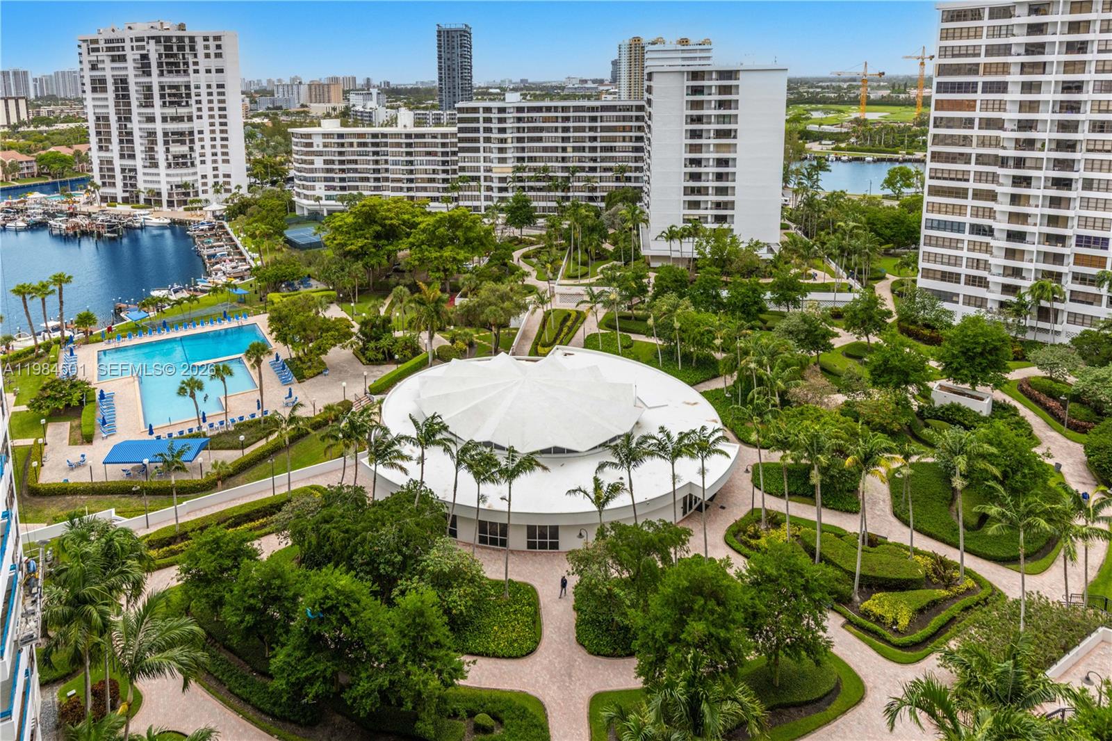 An aerial view shows a circular clubhouse, a swimming pool, and landscaped grounds between buildings — 2500 Parkview Dr # 509, Hallandale Beach FL 33009, HALLANDALE BEACH, FL
