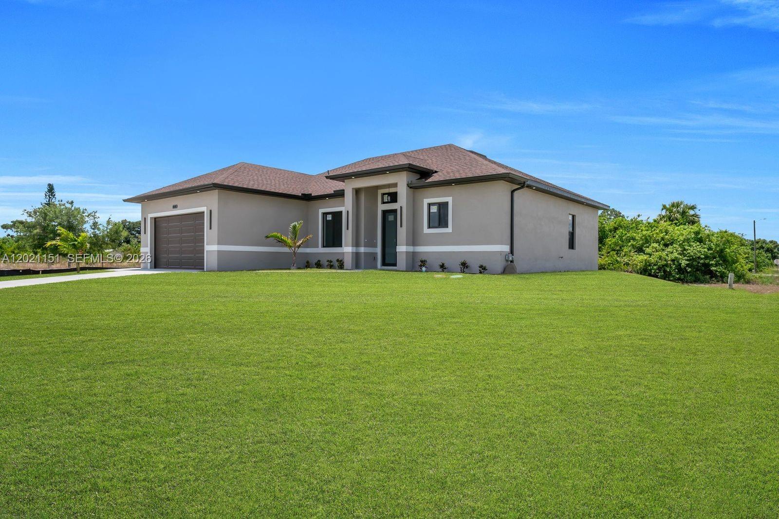 A single-story house with a brown roof, gray stucco exterior, and a two-car garage — 3115 2nd ST SW, Lehigh Acres FL 33976, LEHIGH ACRES, FL