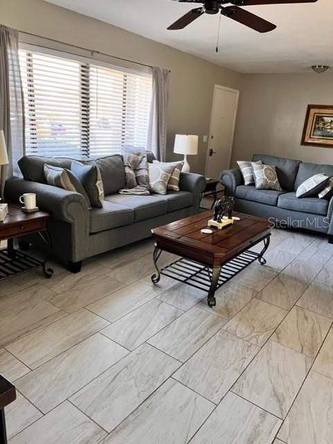 A living room features gray sofas, a wooden coffee table, and light-colored tile flooring — 22497 GLEN AVENUE, PUNTA GORDA, FL