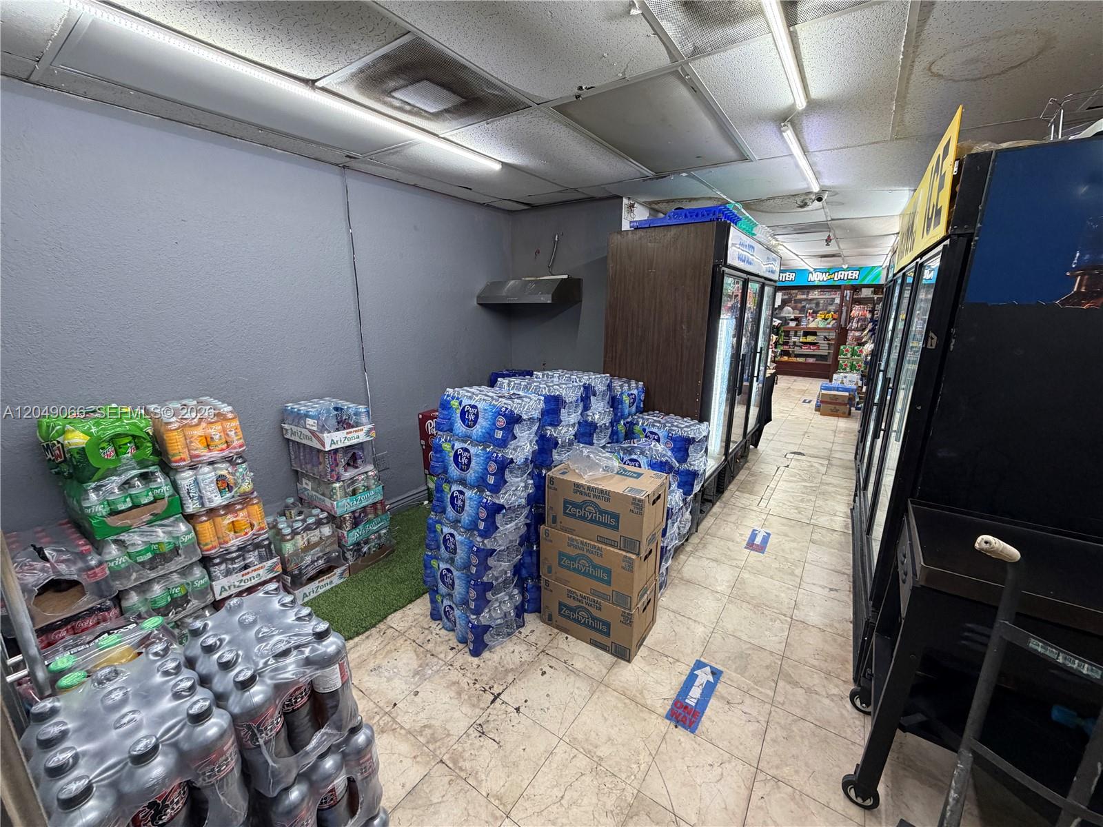 A commercial space features stacks of bottled water and beverages on a tiled floor — 4980 NW 22nd Ave, Miami FL 33142, MIAMI, FL