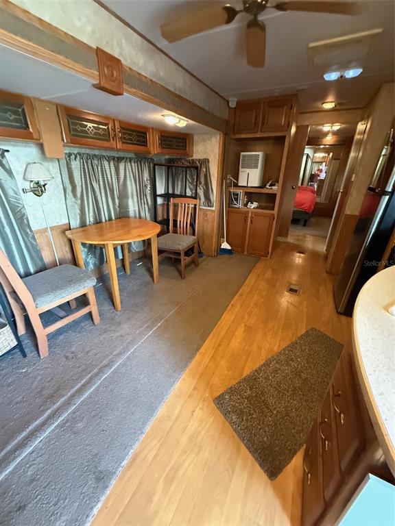 An interior view of a recreational vehicle featuring a dining area and wood-look flooring — 3000 CLARCONA ROAD UNIT 2011, APOPKA, FL
