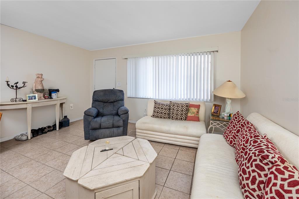 A living room features tile flooring, a white sofa, a blue recliner, and a coffee table — 224 WAVERLY WAY UNIT 4, CLEARWATER, FL