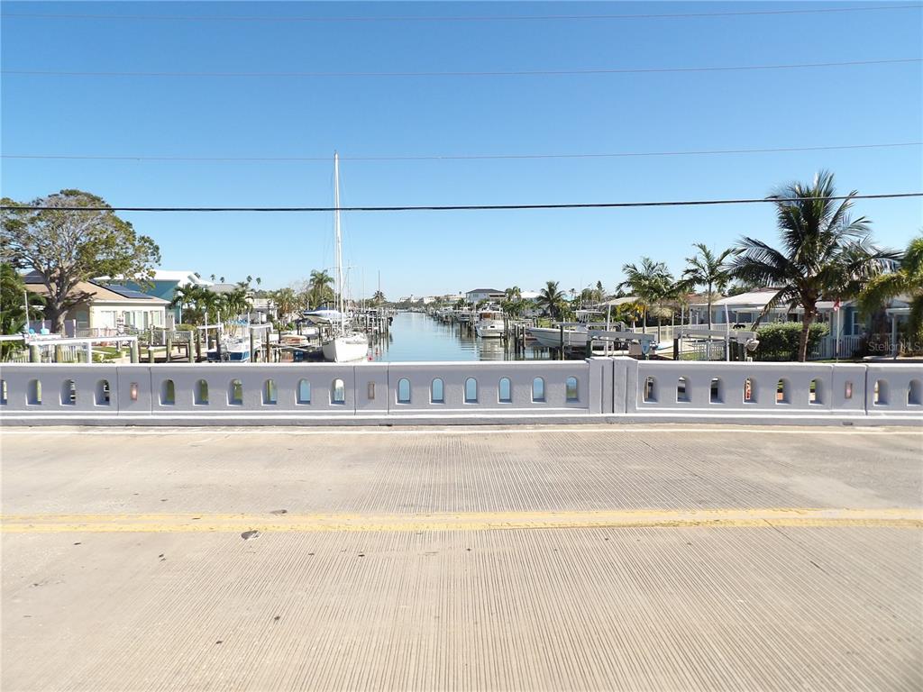 A view from a bridge looking down a canal lined with boats and houses — 497 NORMANDY ROAD, MADEIRA BEACH, FL