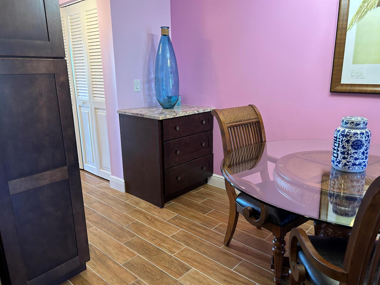 A dining area features a glass-topped table, dark wood furniture, and light purple walls — 3070 Cornwall D # D, Boca Raton FL 33434, BOCA RATON, FL