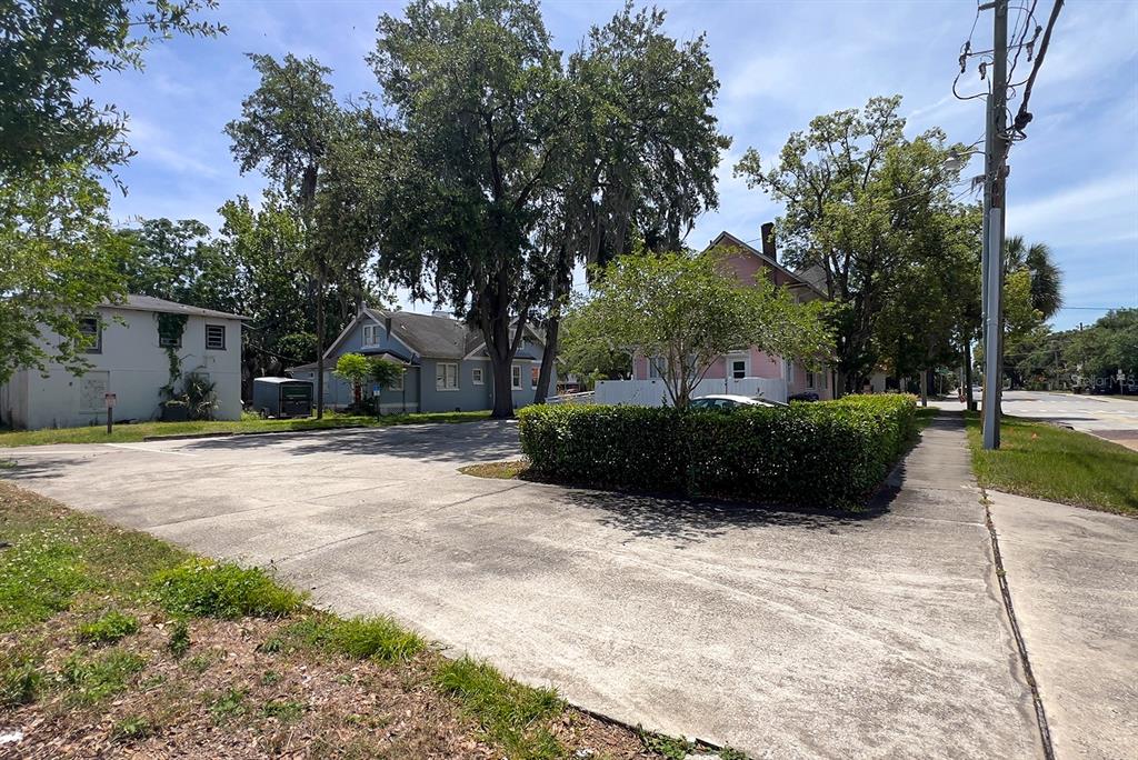 A paved parking lot sits in front of a light blue house and a pink building — 821 EMMETT STREET 2nd Floor, KISSIMMEE, FL