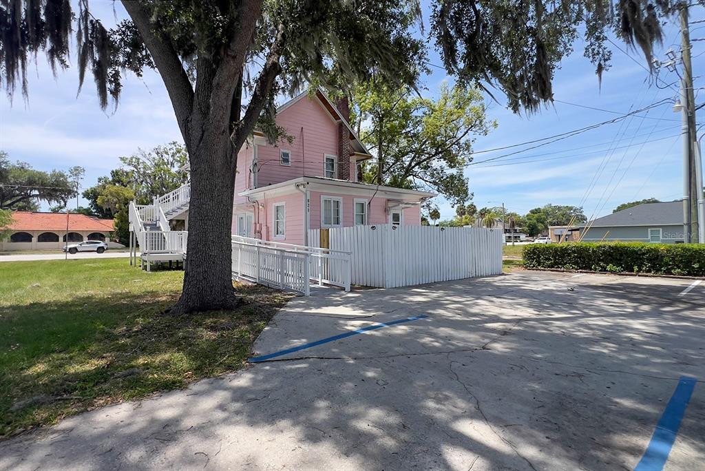 A pink two-story house with a white fence and a wheelchair ramp in a parking lot — 821 EMMETT STREET 2nd Floor, KISSIMMEE, FL