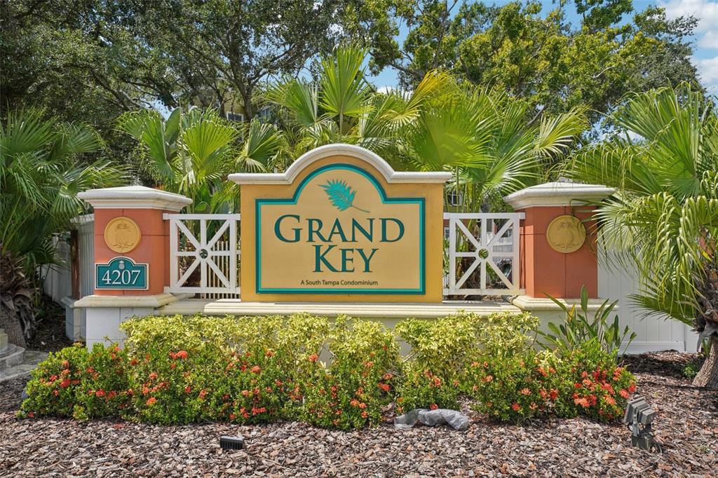 A sign for Grand Key condominiums stands in front of lush palm trees and landscaping — 4207 S DALE MABRY HIGHWAY UNIT 11207, TAMPA, FL