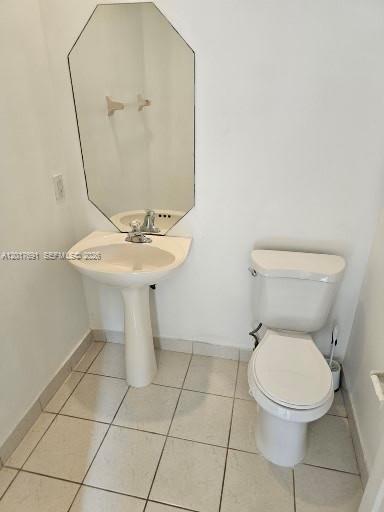 A small bathroom features a pedestal sink, a toilet, and an octagonal wall mirror — 2160 NE 37th Rd, Homestead FL 33033, HOMESTEAD, FL