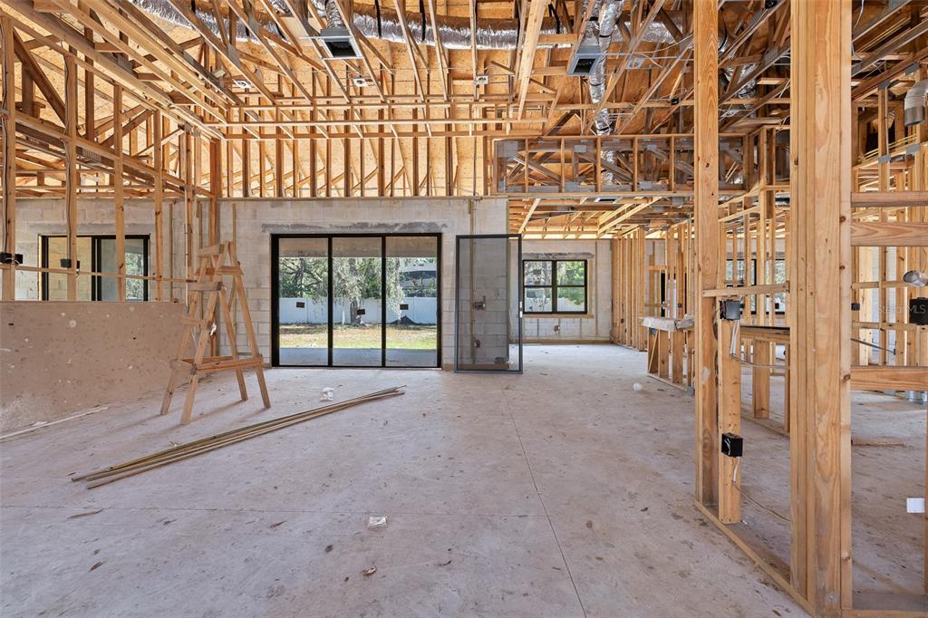 An interior view of a house under construction with exposed wooden framing and concrete walls — 4531 YORKSHIRE LANE, KISSIMMEE, FL