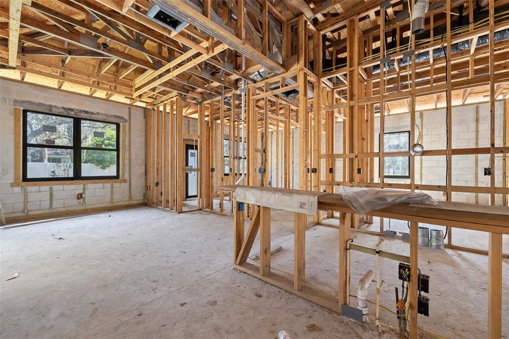 An interior view of a house under construction with exposed wooden framing and concrete walls — 4531 YORKSHIRE LANE, KISSIMMEE, FL