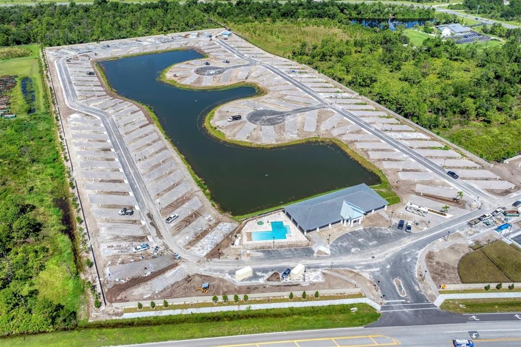 An aerial view shows a new RV park development with a central pond and pool — 9001 GASPARILLA ROAD UNIT 87, PLACIDA, FL