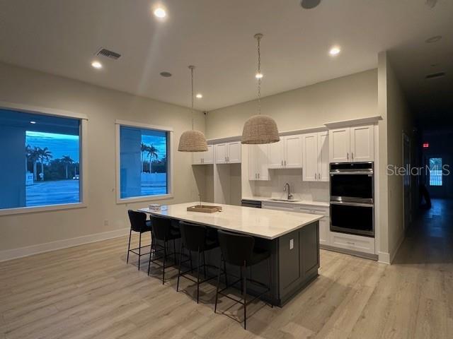 A modern kitchen features a large island with bar seating, white cabinetry, and stainless appliances — 9001 GASPARILLA ROAD UNIT 87, PLACIDA, FL