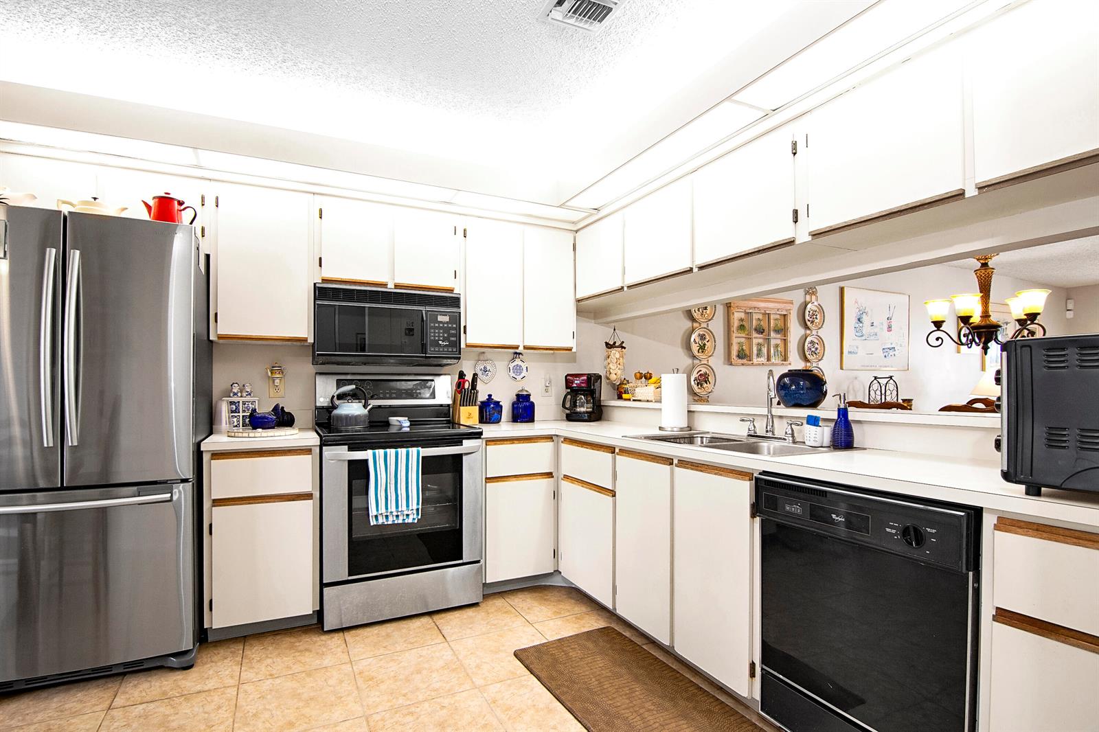 A kitchen with white cabinets, stainless steel appliances, and light-colored tile flooring — 6198 Riverwalk Lane # 2, Jupiter FL 33458, JUPITER, FL