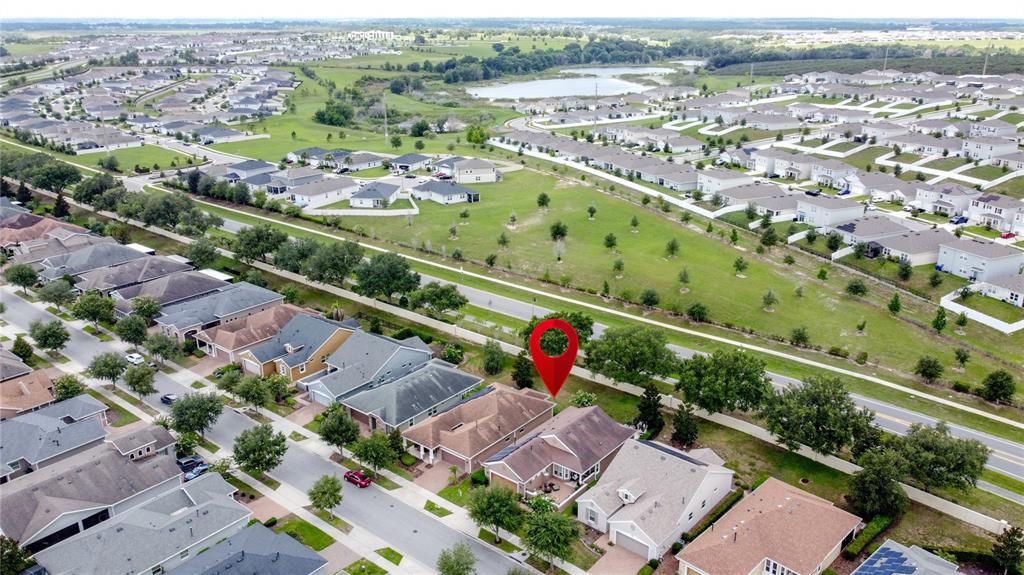 A tan stucco house with a two-car garage, a gated courtyard, and landscaped front yard — 255 SILVER MAPLE ROAD, GROVELAND, FL