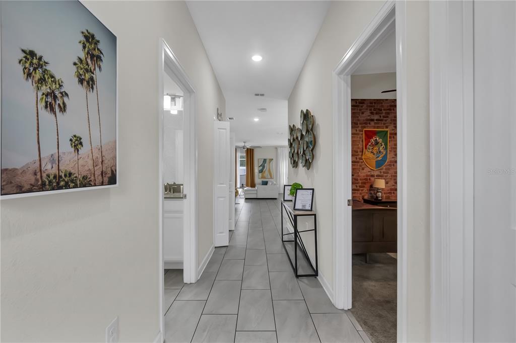 A tiled hallway leads past a bathroom and bedroom toward a living area — 448 OCEAN COURSE AVENUE, DAVENPORT, FL