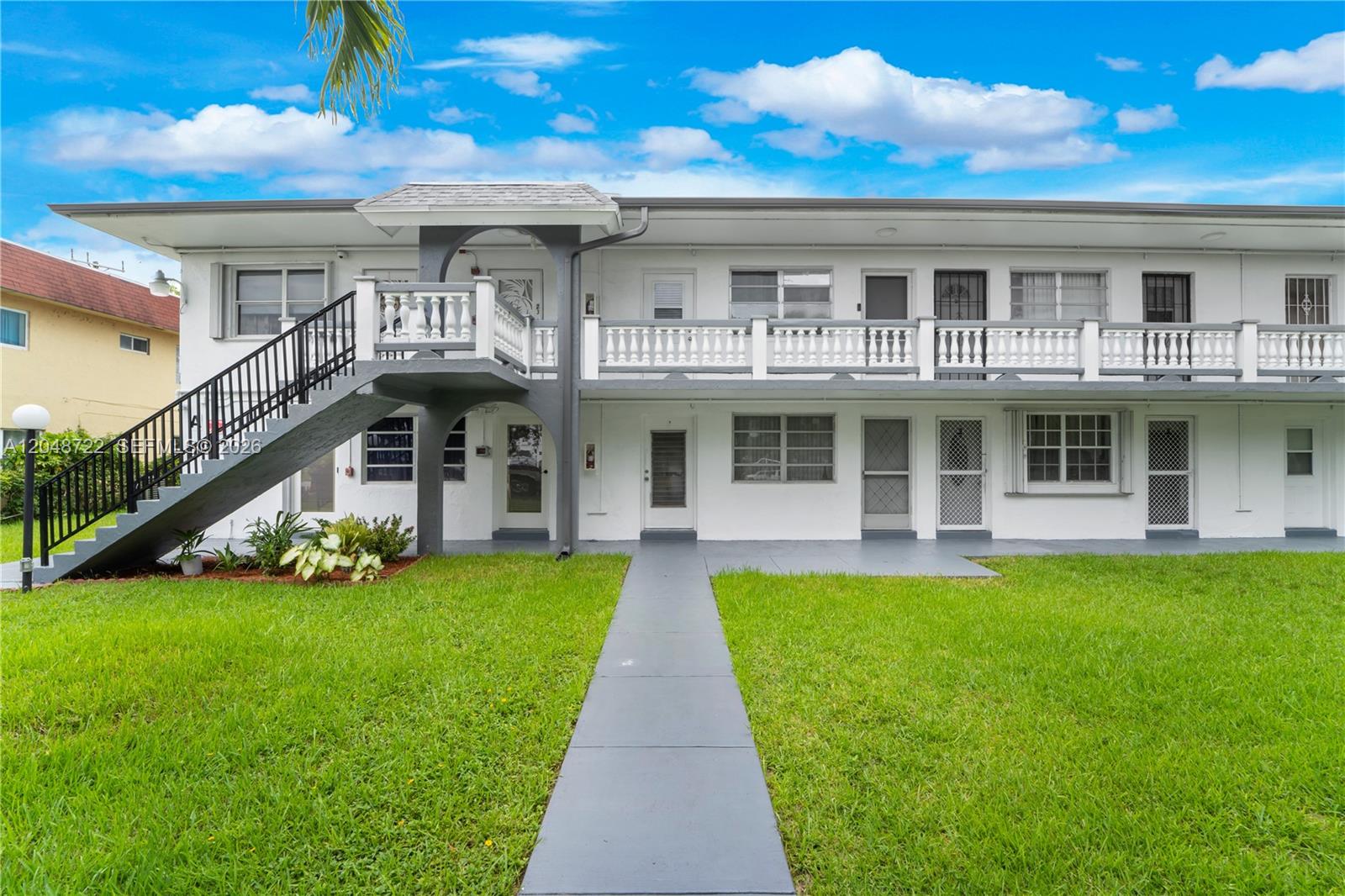 A two-story white apartment building features an exterior staircase and a second-floor balcony — 20337 NE 2nd Ave # 2, Miami FL 33179, MIAMI, FL