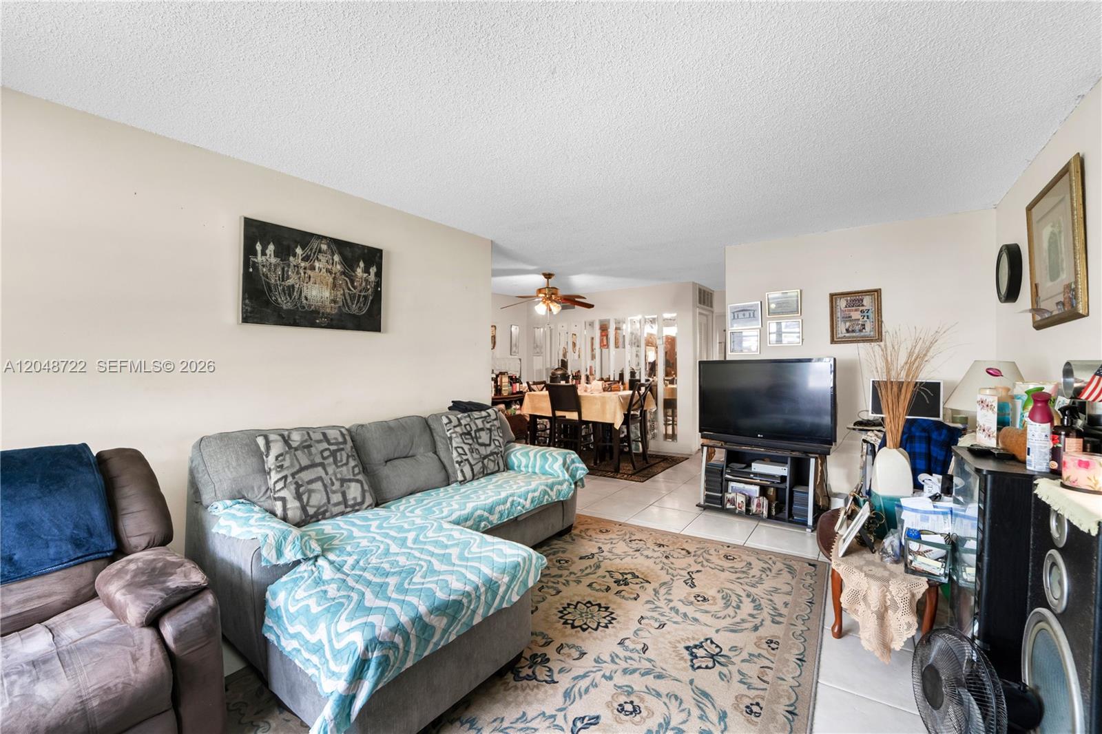 A living room features a grey sectional sofa, a patterned area rug, and a television — 20337 NE 2nd Ave # 2, Miami FL 33179, MIAMI, FL