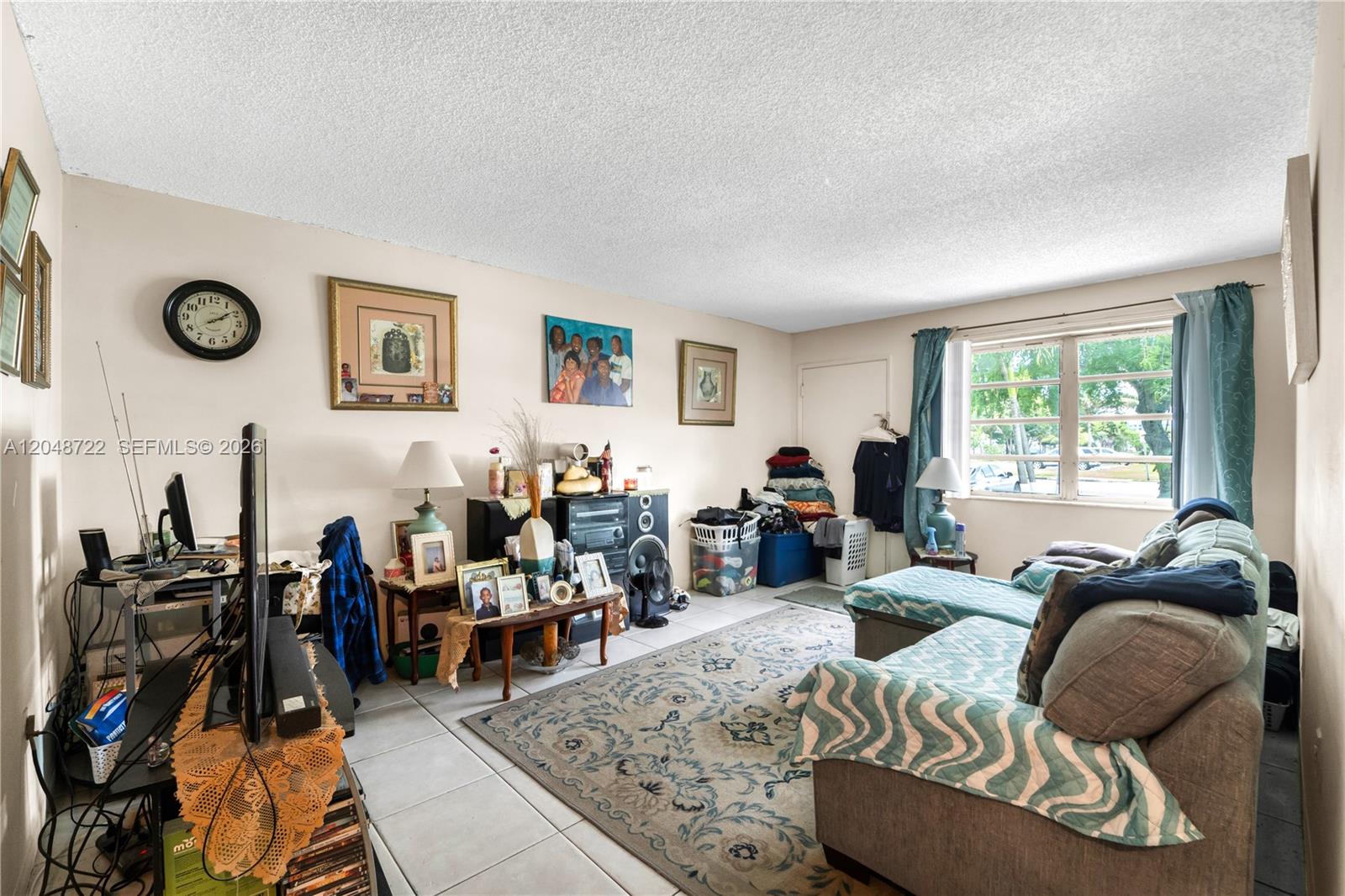 A living room features a sofa, a patterned area rug, and various decor on the walls — 20337 NE 2nd Ave # 2, Miami FL 33179, MIAMI, FL