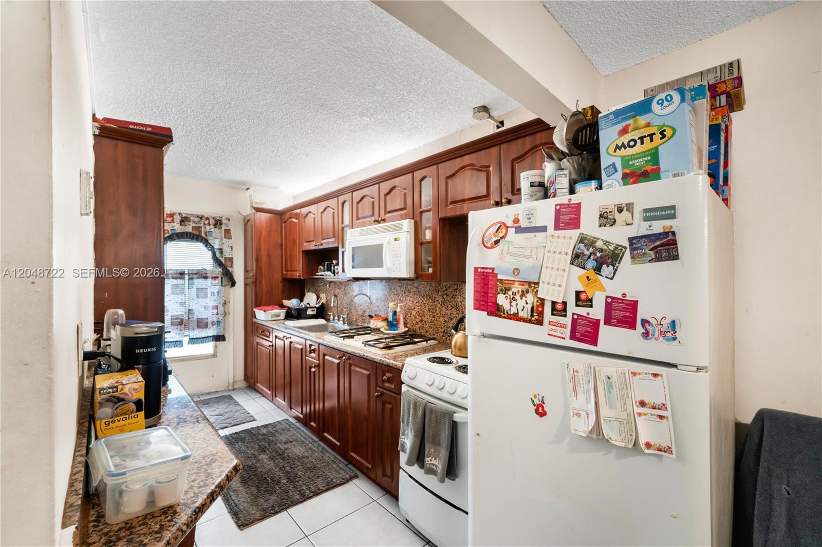 A kitchen features wood cabinets, granite countertops, a white stove, and a white refrigerator — 20337 NE 2nd Ave # 2, Miami FL 33179, MIAMI, FL