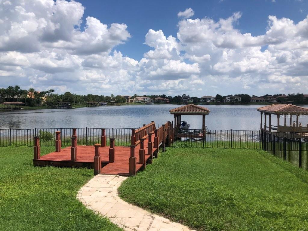 A wooden dock with a gazebo extends into a lake from a grassy backyard — 1238 LAKE WHITNEY DRIVE, WINDERMERE, FL