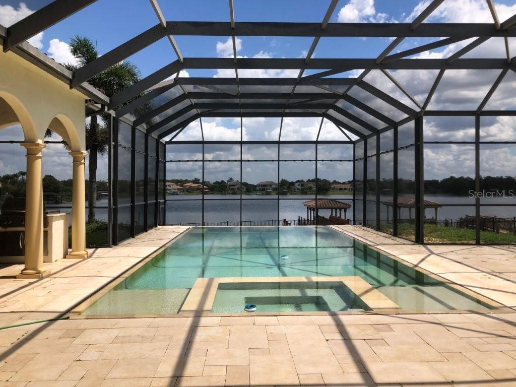 A screened-in swimming pool and spa overlook a lake with a gazebo — 1238 LAKE WHITNEY DRIVE, WINDERMERE, FL