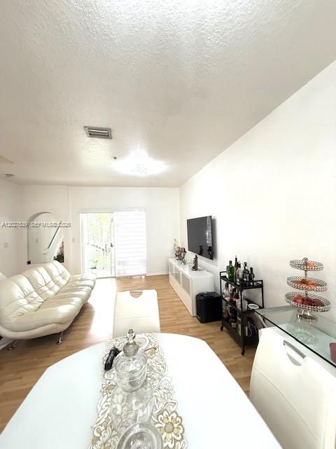A living and dining area features a white sofa, a television, and a dining table — 5610 NW 114th Pl # 202, Doral FL 33178, DORAL, FL
