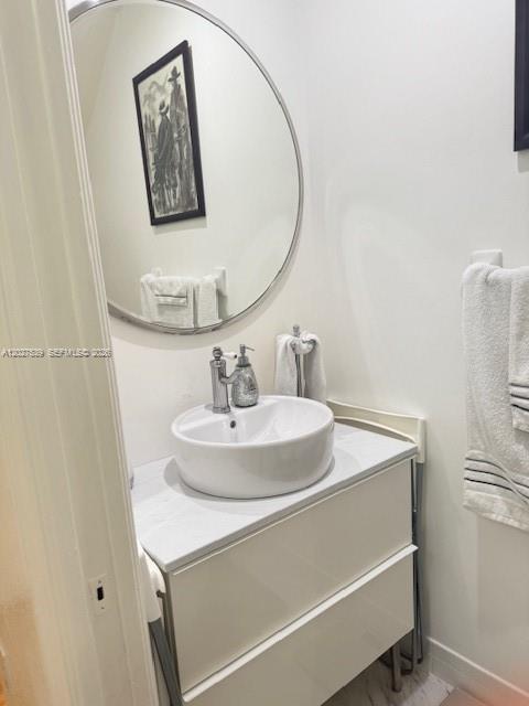 A bathroom features a white vessel sink on a vanity with a round wall mirror — 5610 NW 114th Pl # 202, Doral FL 33178, DORAL, FL