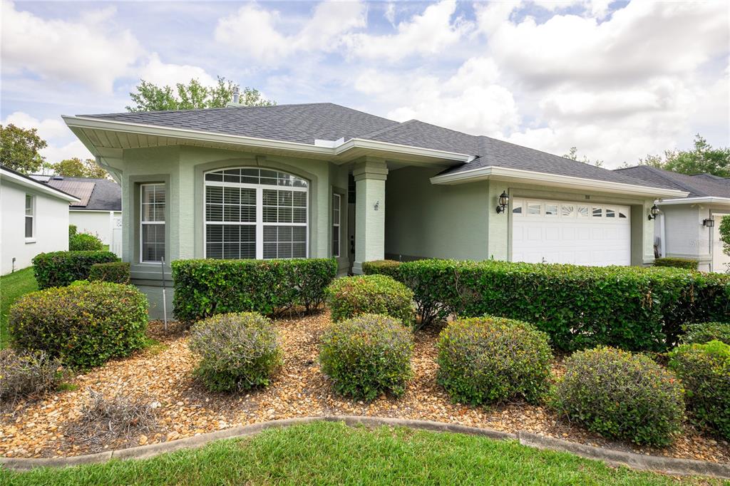 A single-story house with light green stucco siding, a shingled roof, and a two-car garage — 708 CRESTWOOD DRIVE, ST AUGUSTINE, FL