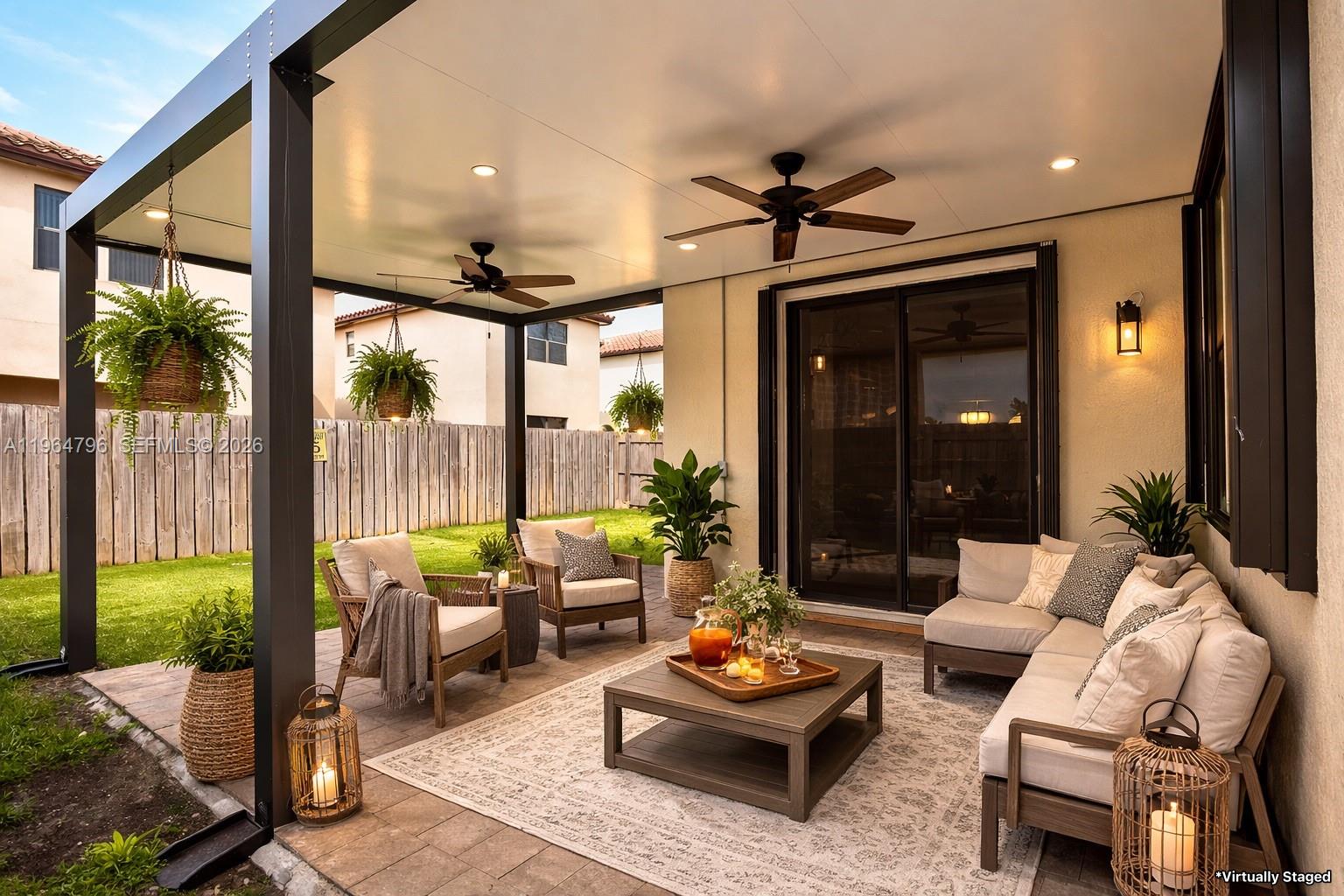 A covered patio features a seating area with a sectional, armchairs, and a coffee table — 526 SE 35th Ave, Homestead FL 33033, HOMESTEAD, FL