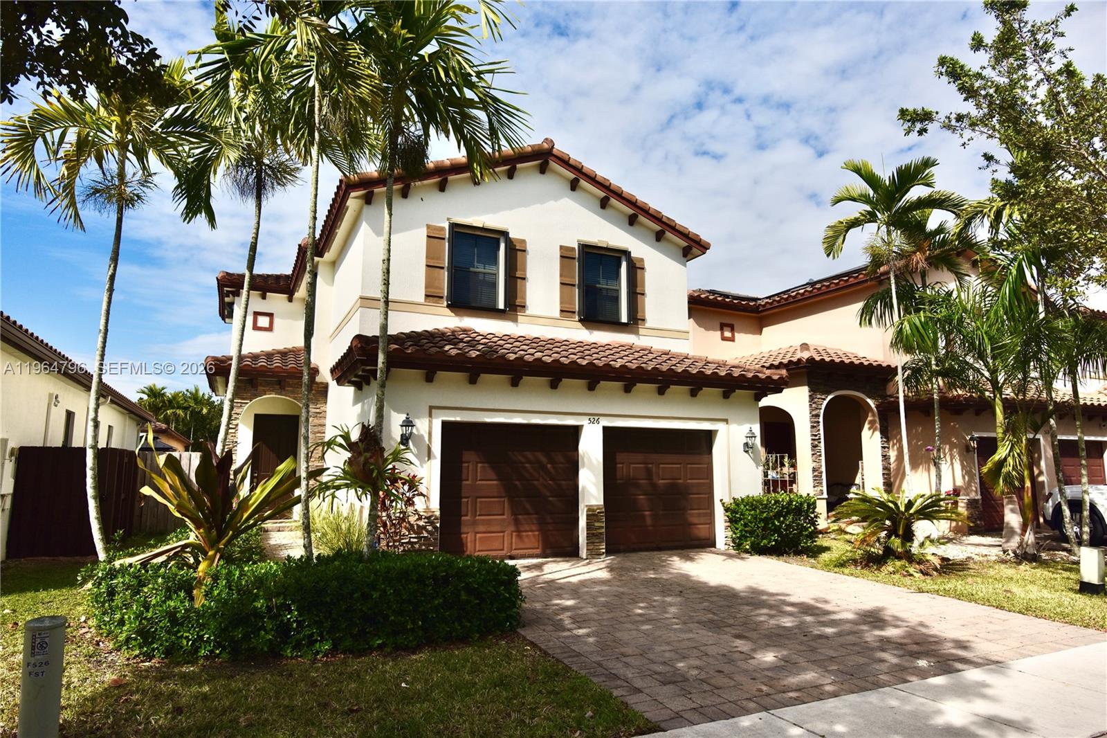 A two-story house with a two-car garage, tile roof, and palm trees in the front — 526 SE 35th Ave, Homestead FL 33033, HOMESTEAD, FL