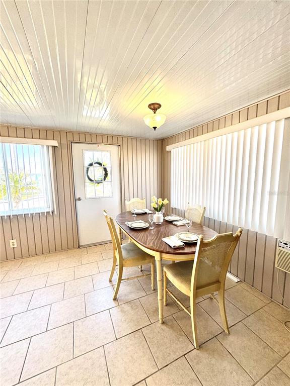 A dining room features a wooden table, four chairs, vertical blinds, and tiled flooring — 340 PEACE MANOR, PALMETTO, FL