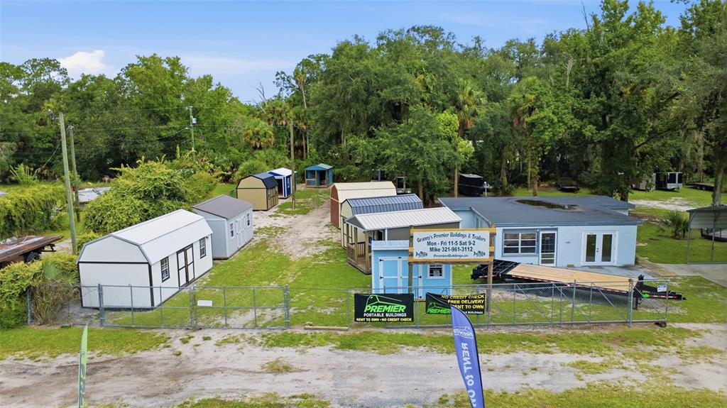 An aerial view shows a sales lot featuring several portable storage sheds and a small office — 2819 W STATE ROAD 44, DELAND, FL