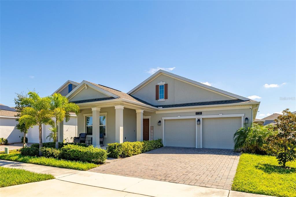 A single-story house with a paved driveway, two-car garage, and a covered front porch — 1739 GOOD NEIGHBOR LOOP, KISSIMMEE, FL