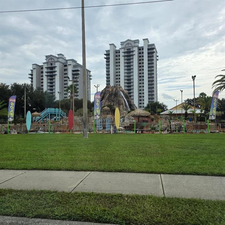 A miniature golf course with a central volcano feature sits in front of two tall buildings — 13427 BLUE HERON BEACH DR UNIT 1405, ORLANDO, FL