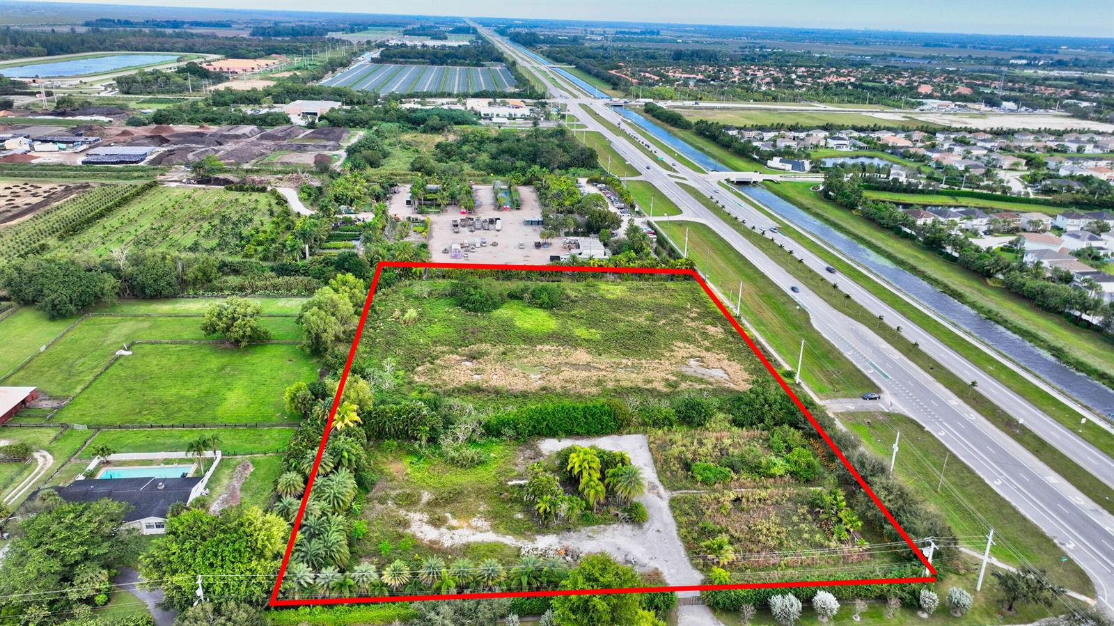 An aerial view shows a rectangular, undeveloped plot of land outlined in red — 15445 S State Road 7 Road, Delray Beach FL 33446, DELRAY BEACH, FL