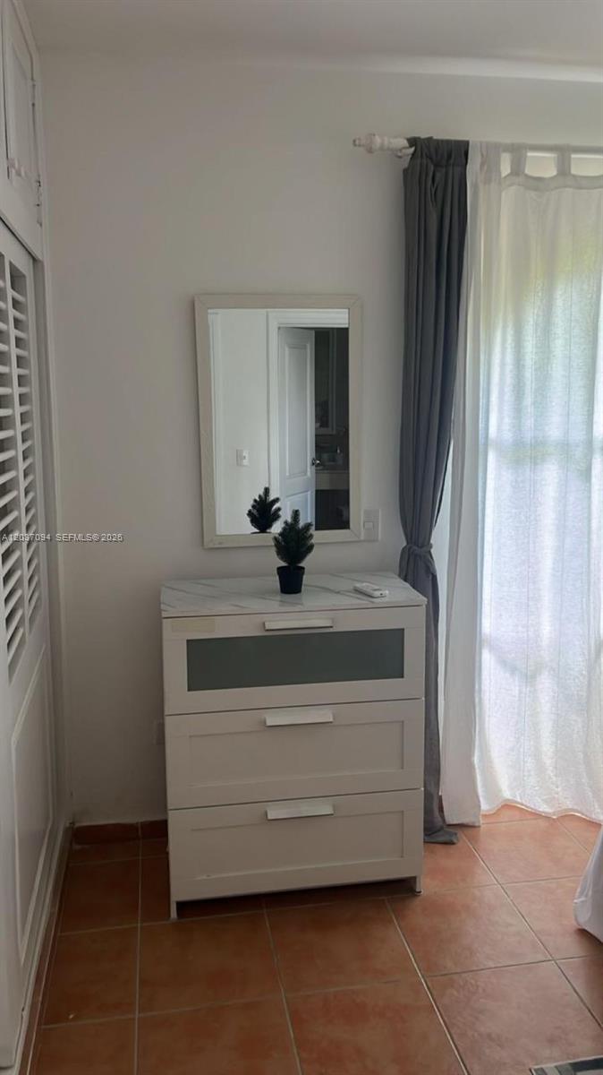 A white dresser with a mirror sits against a wall next to a window — 0 Bávaro # 0, FL, FL